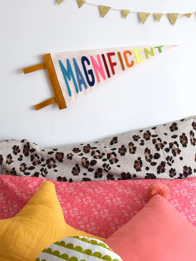 pennant flag with the word magnificent sewn on in bright letters