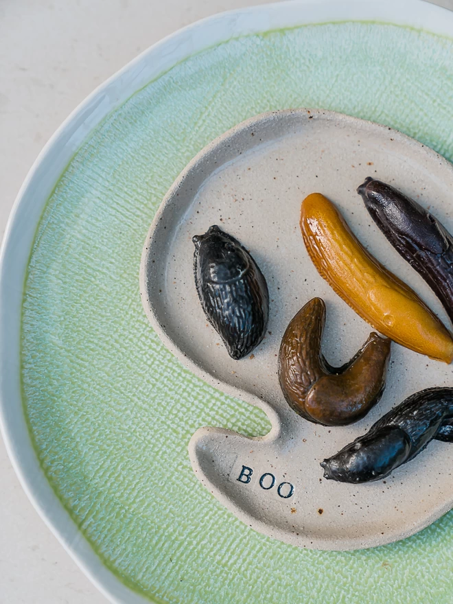 Solid chocolate slugs in various slimy poses on a plate