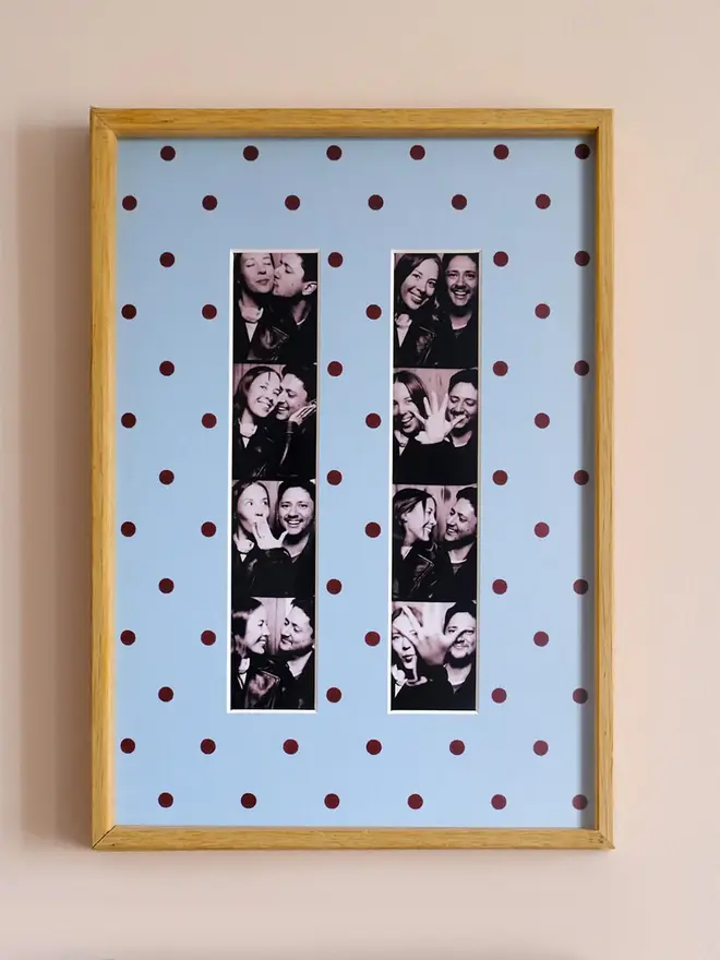 polka dot photo booth strip mount. a framed blue polka dot photo mount with two photo strips inside.