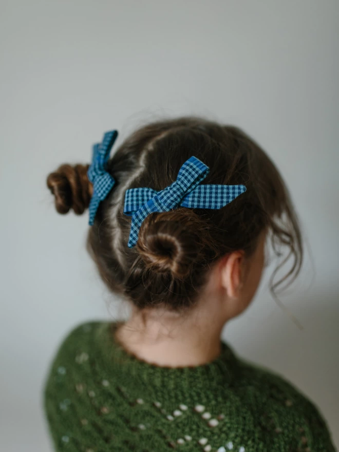 little girl wearing hair bows in blue gingham