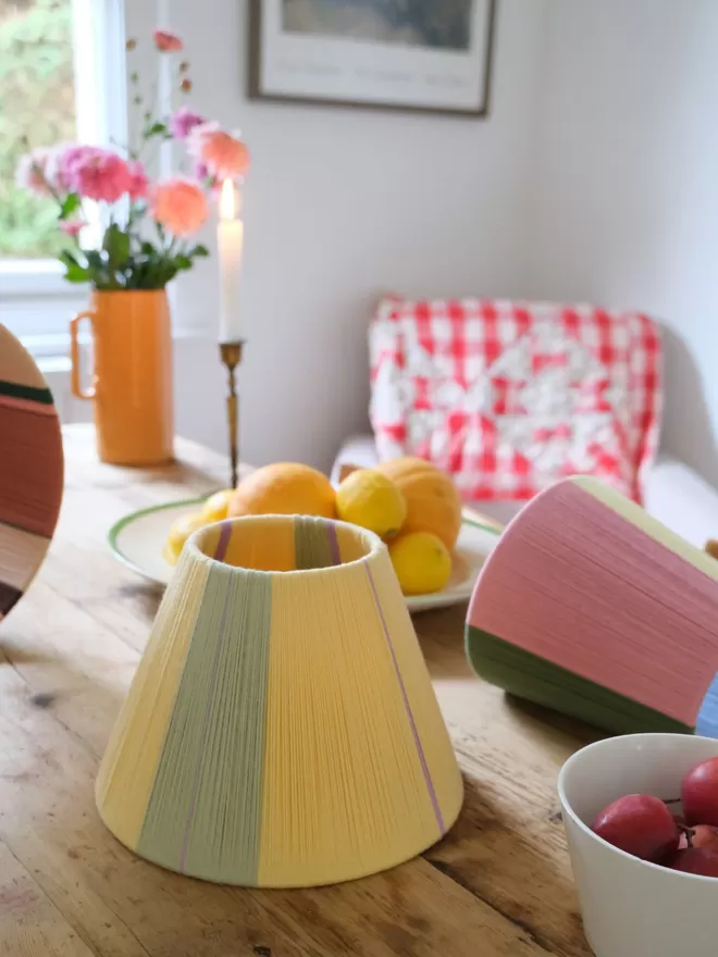 Lifestyle image of Butter Yellow lampshade on table. 