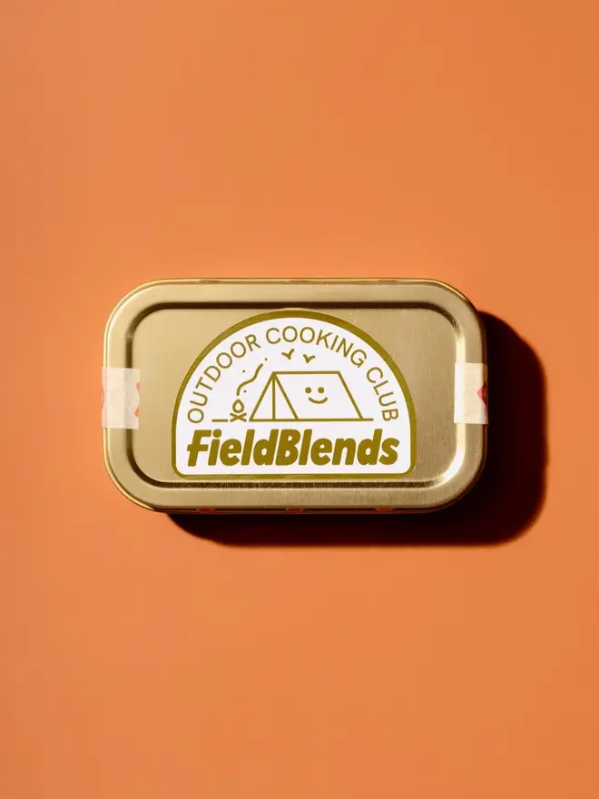 Smokey Jalapeño & Peach Camping Tin, on a table. 