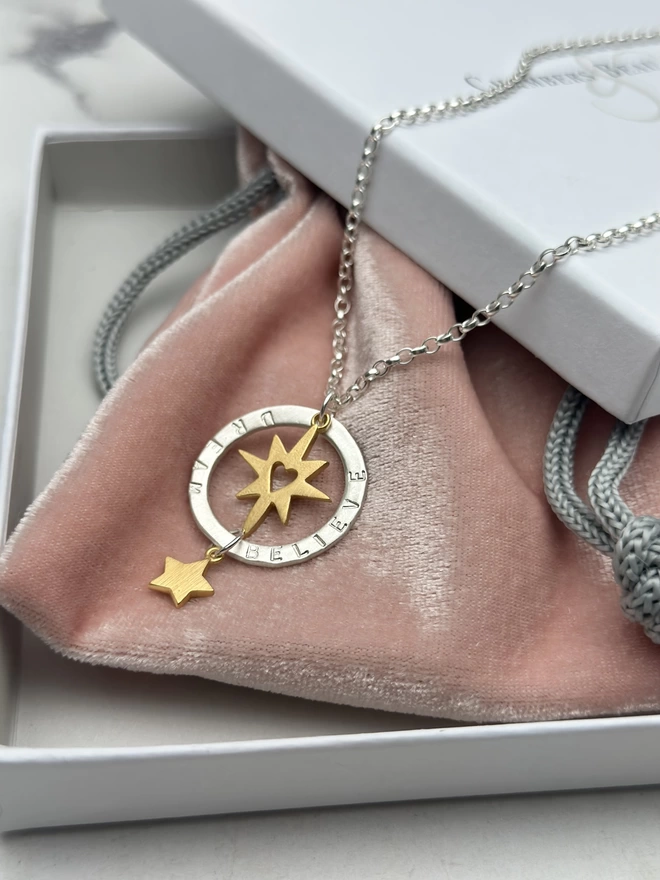 sterling silver chain with personalised silver halo charm. suspended within the halo is a gold starburst charm with cutout heart, with gold mini star suspended from the bottom of the halo