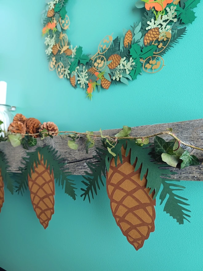 Pincecone Christmas Bunting displayed on mantelpiece under papercut wreath