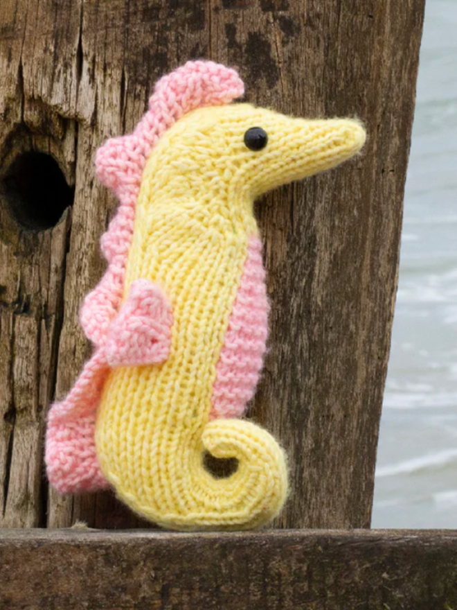 Seahorse Knit Kit. A knitted seahorse in yellow and pink.
