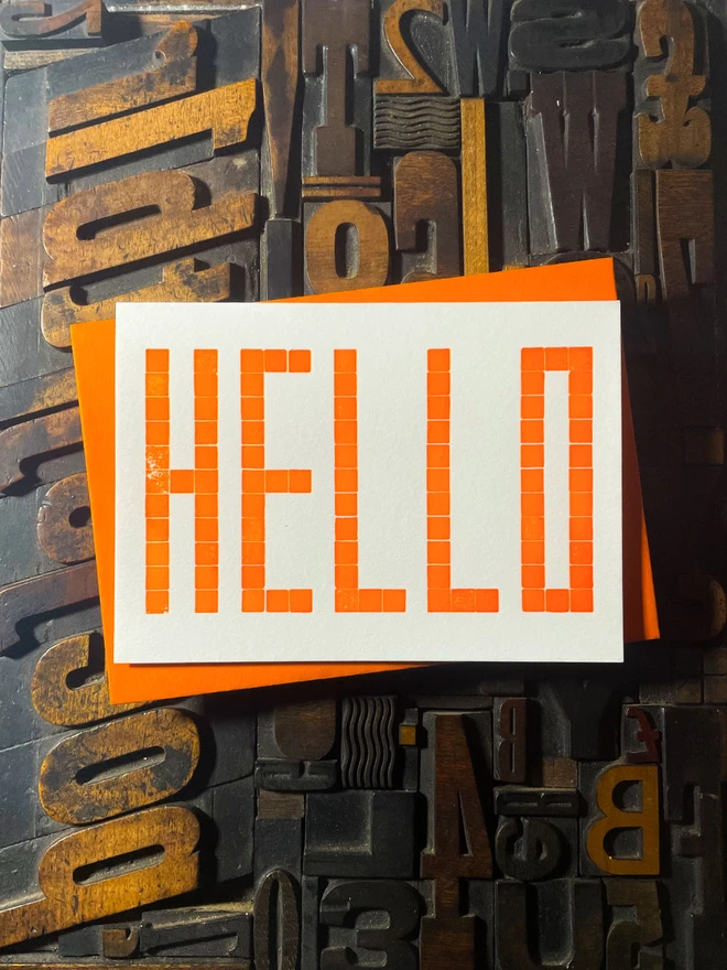 Letterpress HELLO postcard printed from a grid of square wooden type blocks in fluorescent yellow ink, deeply impressed on thick 350gsm Colorplan Pristine White card.