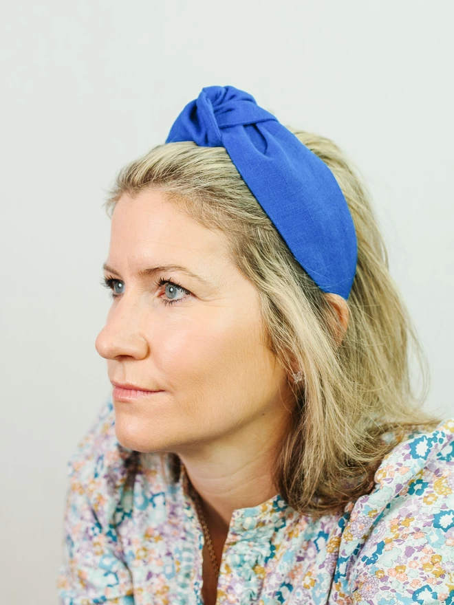 woman in bright blue linen hairband and liberty shirt