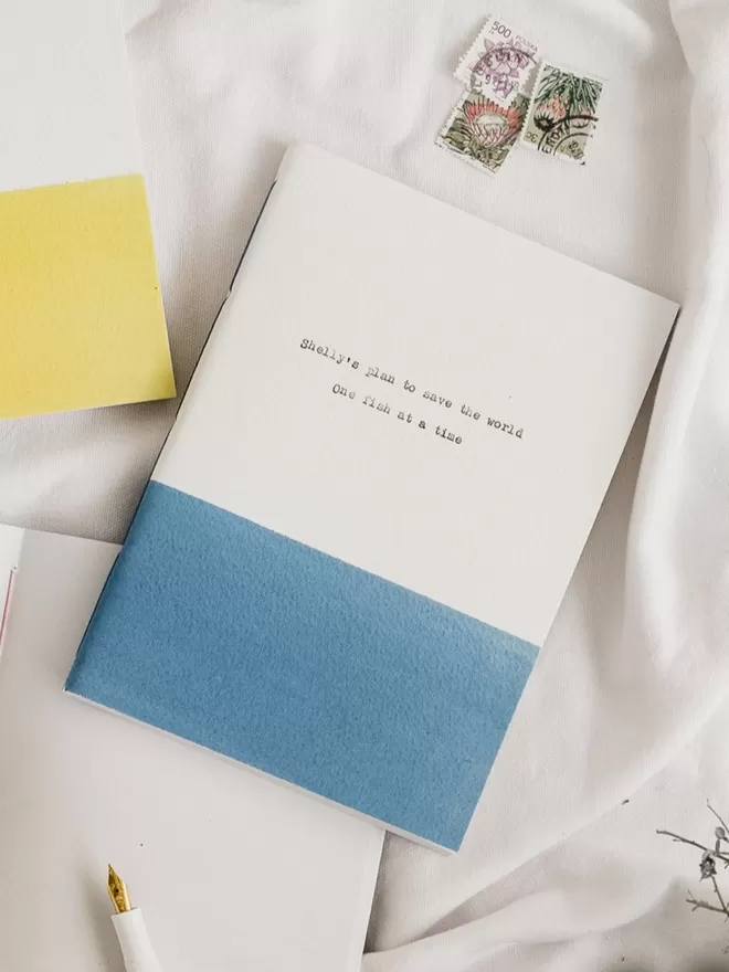 blue and white personalised notebook with typed text on the cover