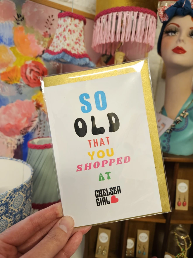 A photograph of the front of a humorous A6 greeting card illustrated using brightly coloured text and the retro shop logo. The text says so old you shopped at Chelsea Girl
