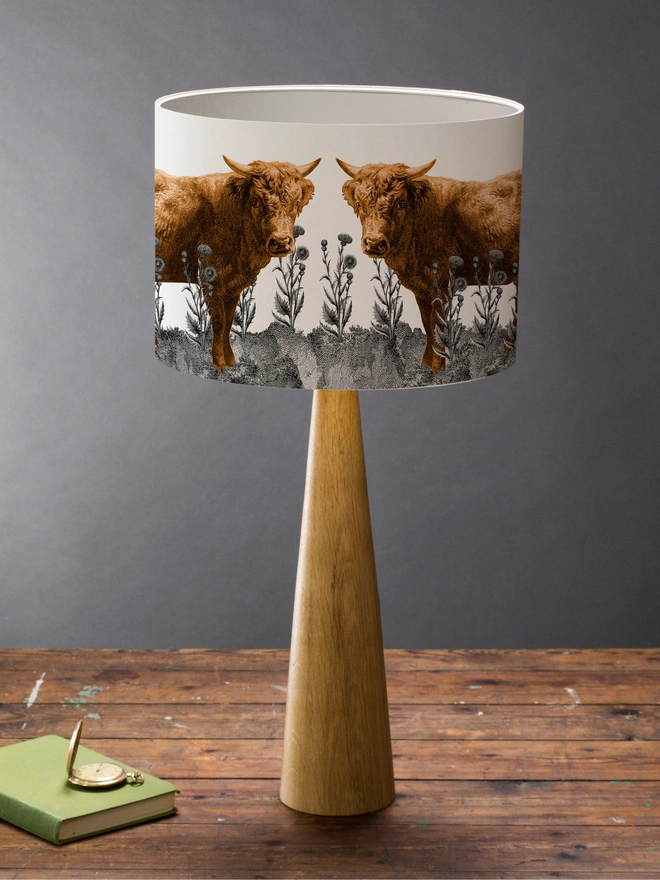 Lampshade of Highland Cow in a field of Scottish thistles