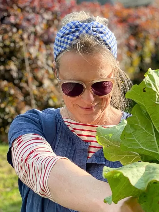 Vanessa Rose Ines Hairband in Bright Blue Gingham seen on a woman gardening.