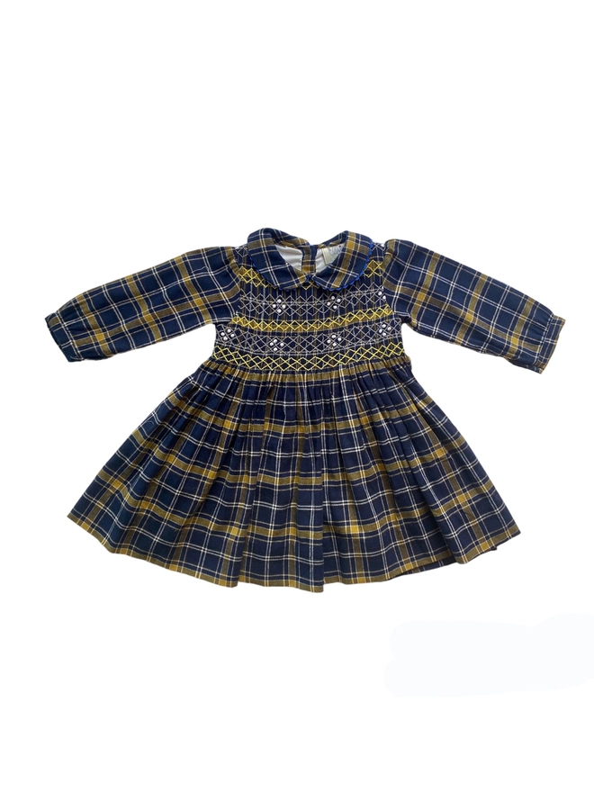 A navy and yellow tartan dress with hand smocked detail and a peter pan collar