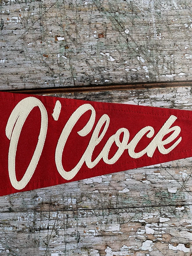 A close up section of a red Pimms o'clock pennant flag