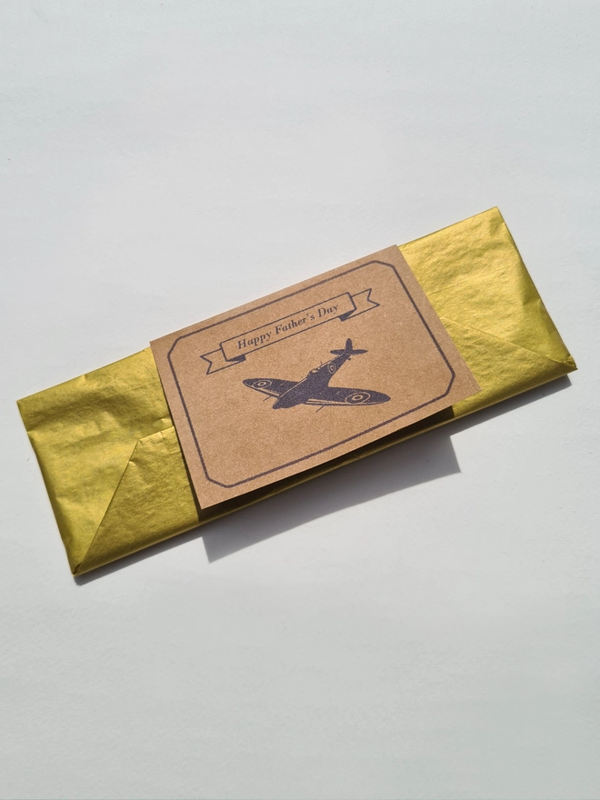 leather spitfire bookmark gift wrapped in gold tissue paper with a gift card printed with a blue spitfire plane