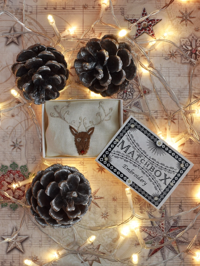 Displayed in its matchbox surrounded with fairy lights and pinecones.