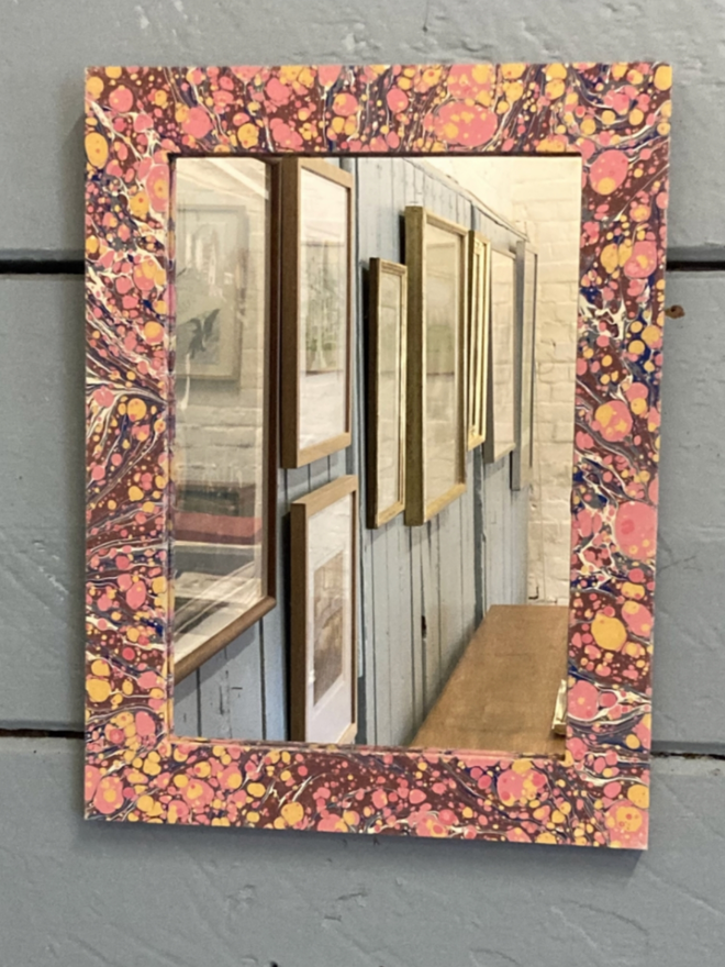 Small Mirror. A small mirror on a wall.