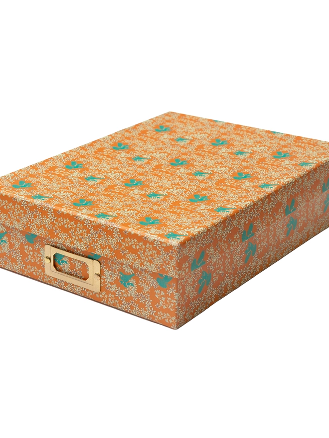 Corali Quartz Orange Portfolio Box, a colourful portfolio sitting on a plan surface.