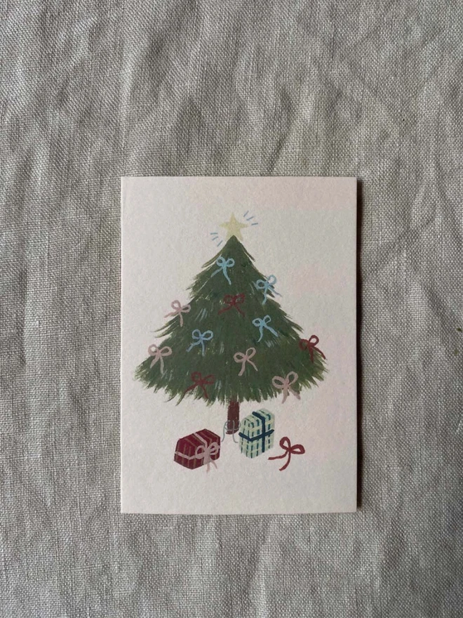 christmas card with decorated tree with bows on and presents 