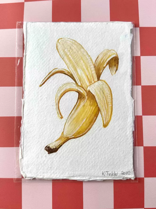 Katie Tinkler illustration of banana in front of a chequered background