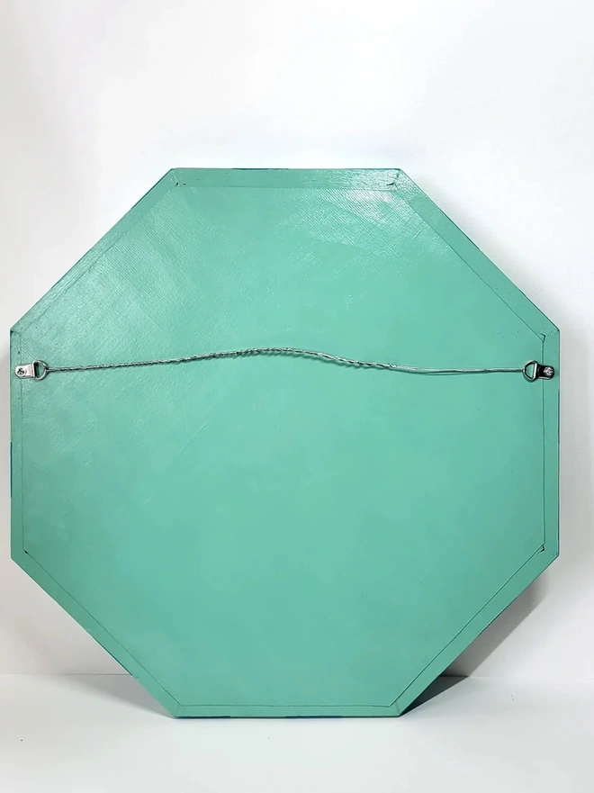 back view of hexagon shaped wooden mirror hand painted in mint green