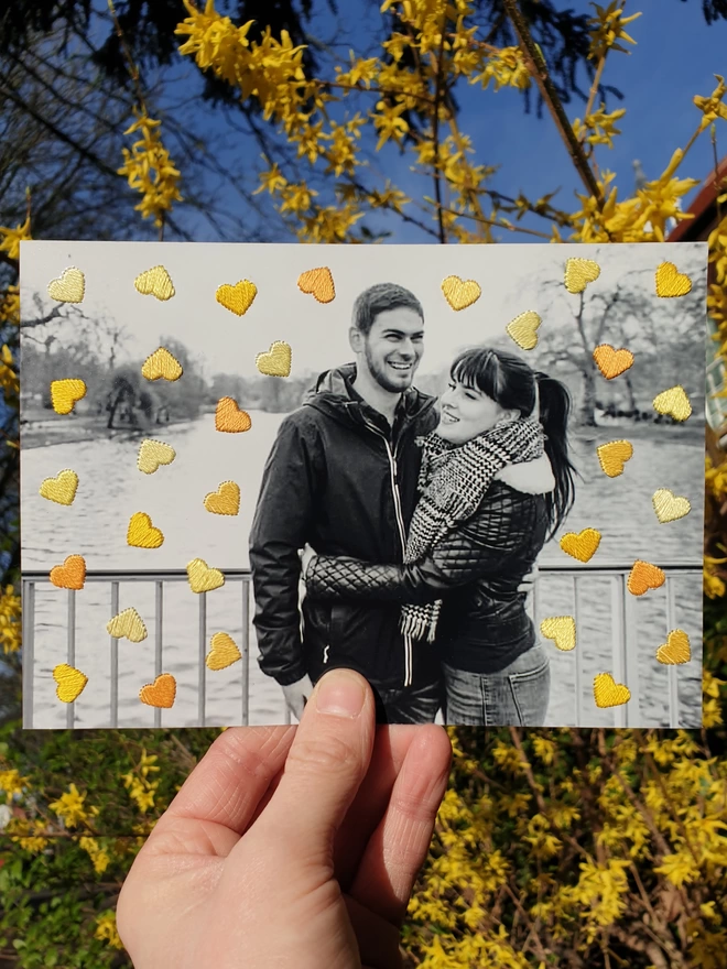 B&W couple photo, with hand embroidered shades of yellow hearts held against yellow flowers