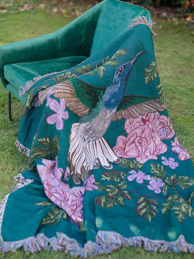 Joy Hummingbird Woven Blanket on chair