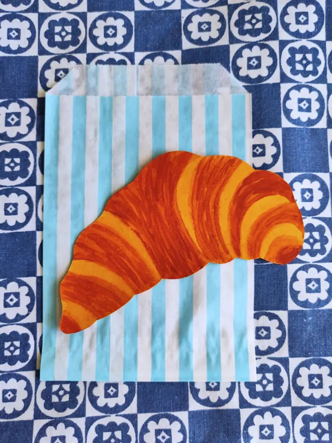 paper croissant painting cut out with striped paper sleeve
