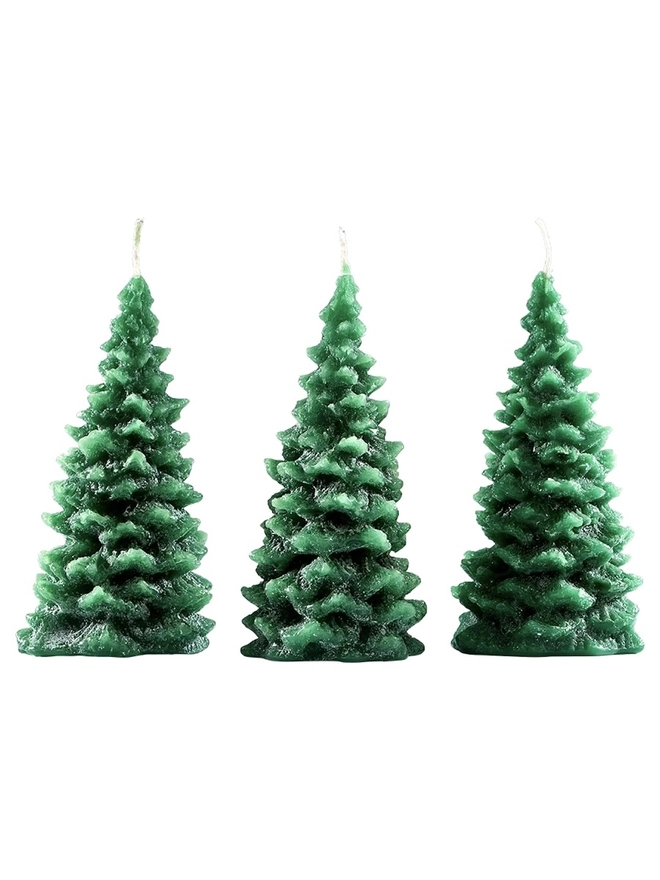 Green Or Red Christmas Tree Candle (Set Of 3). a product shot of three green christmas tree shaped candles standing side by side on a plain white background. each candle features a textured, layered pine branch design tapering to a point, with a wick emerging from the top. the deep green wax has a slightly variegated finish, giving the candles a realistic, snow-dusted fir tree appearance.