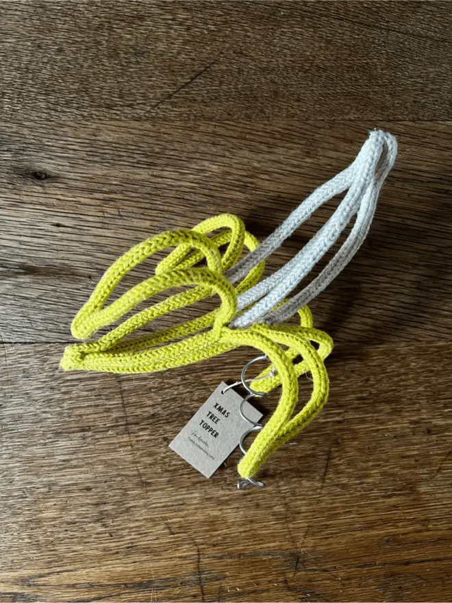 String and wire sculpture in the shape of a peeled banana resting on an oak table