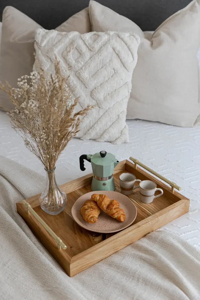 Oak and Brass Serving Tray, a wooden serving tray sat on a bed filled with food and drinks, accompanied by a vase. 