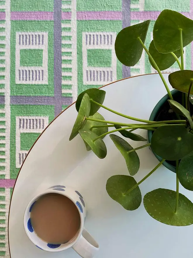 Labourdonnais Flatweave Rug, a colourful rug in a living room. It is accompanied by other household items. 