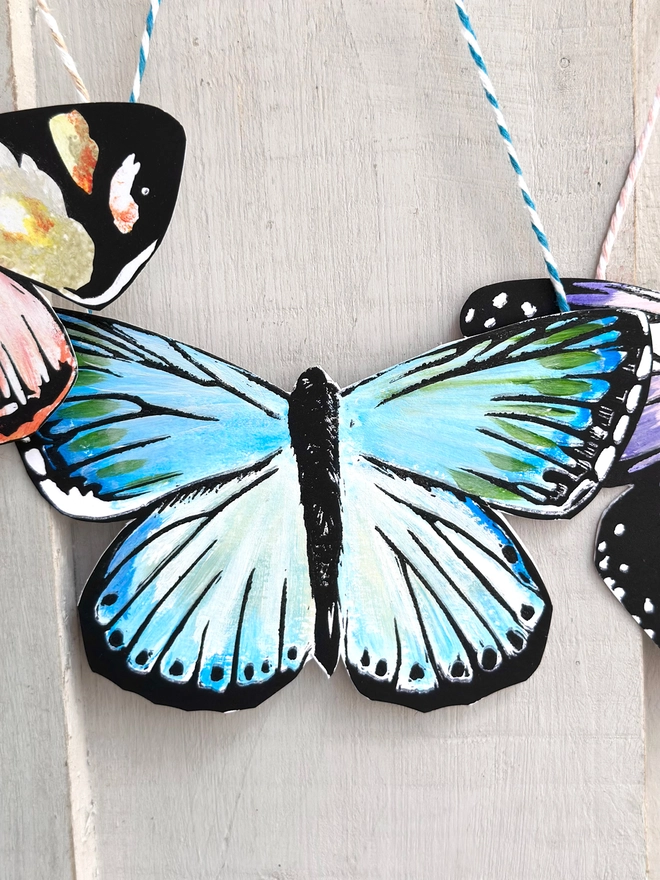 3 Hand Painted Butterflies. Set Of Linocut Wall Hangings. Close up of teal butterfly shown