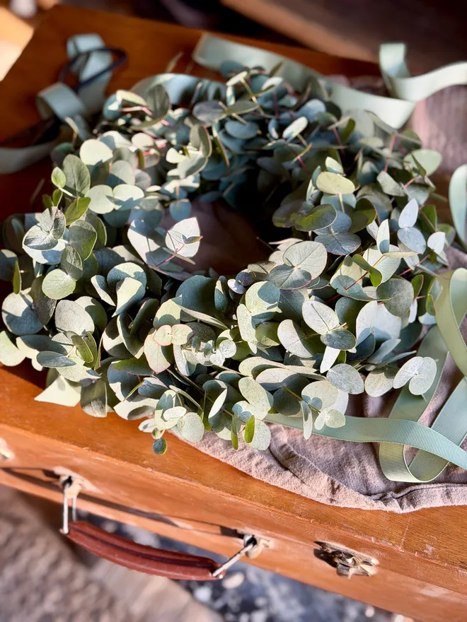 Eucalyptus wreath on fabric with ribbon in natural light