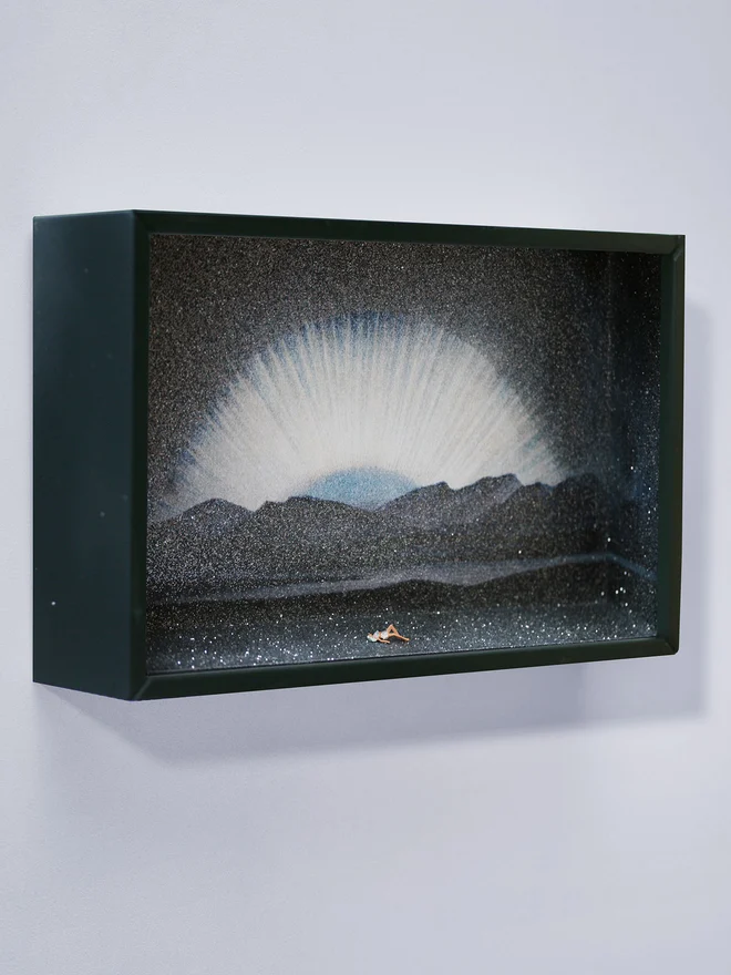 Miniature scene in an artbox showing a tiny woman 'moonbathing' against a sparkling cosmic moonrise backdrop.