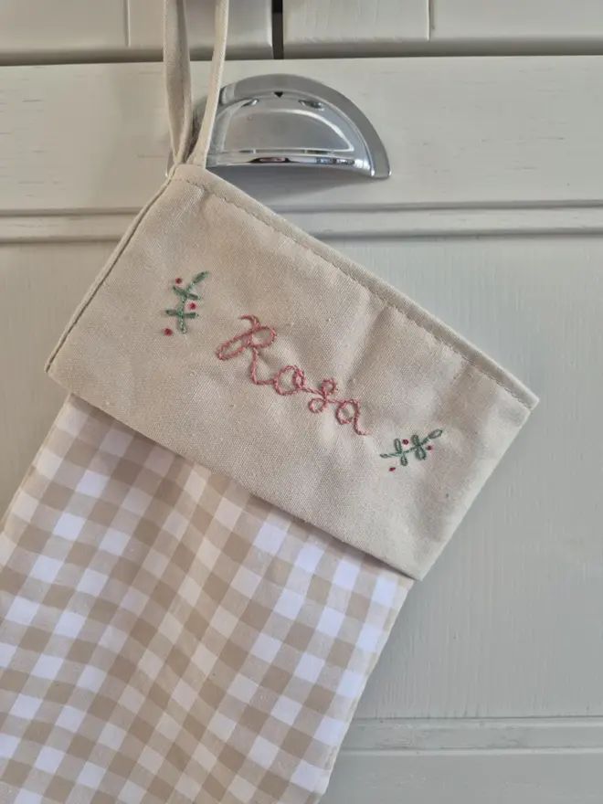 blue gingham stocking with personalised embroidered name hanging