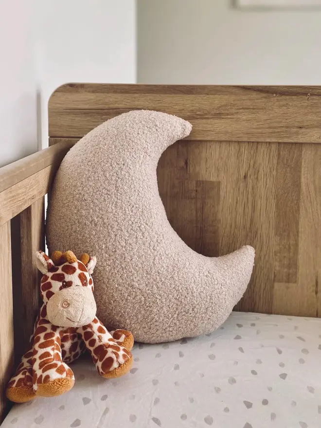 boucle moon pillow. a moon shaped pillow cushion in beige.