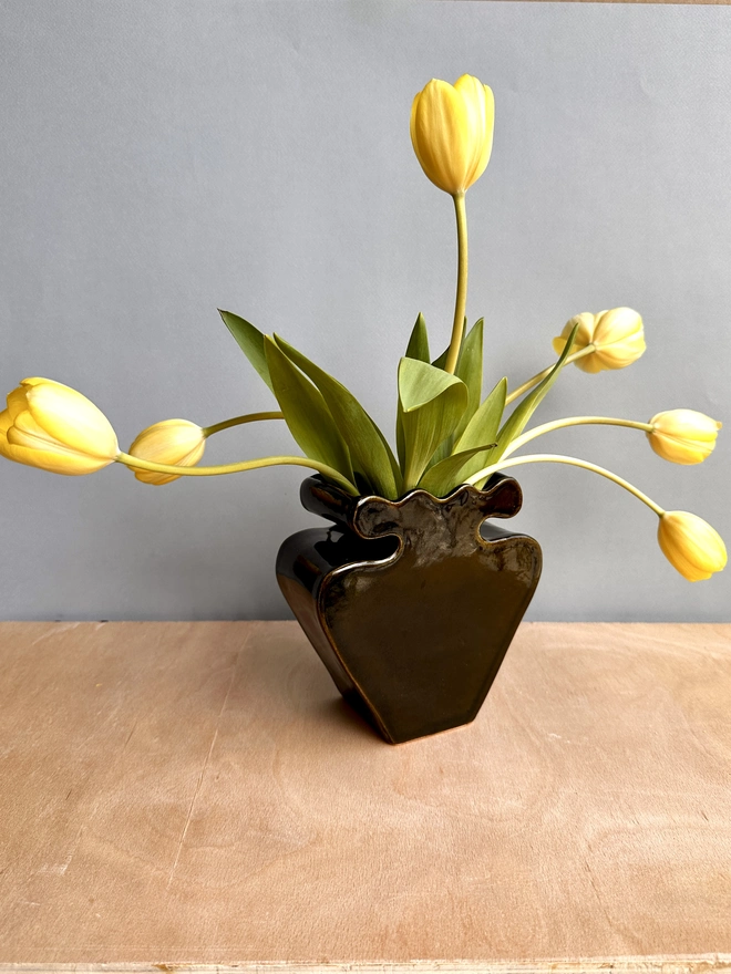 A black vase with tulips