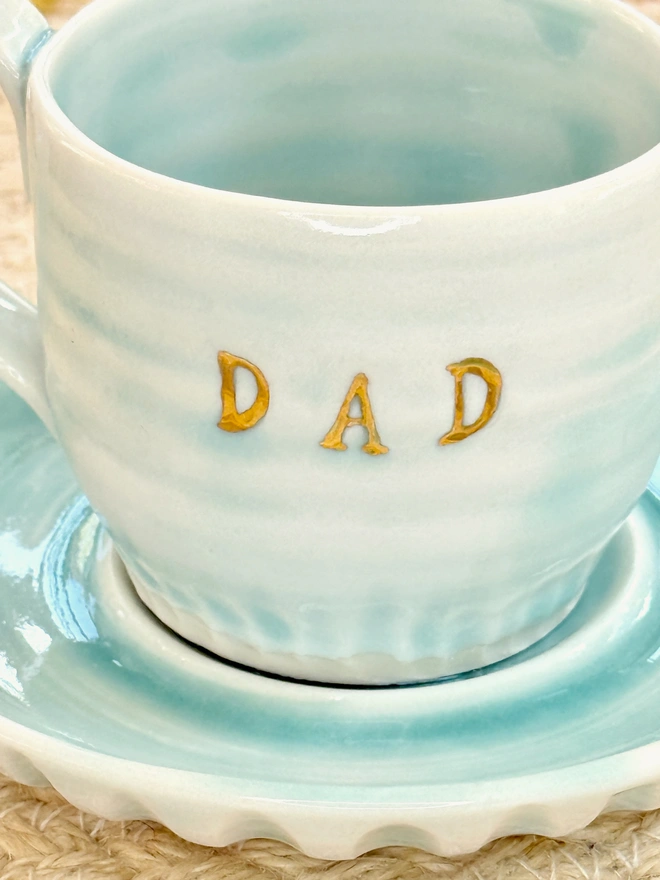 detail of gold lustre DAD lettering on side of espresso cup and saucer