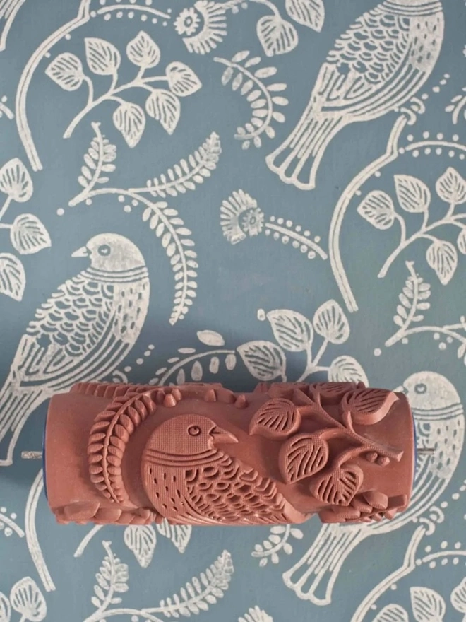 Tuvi Patterned Paint Roller, with a blue and white floral pattern behind. 