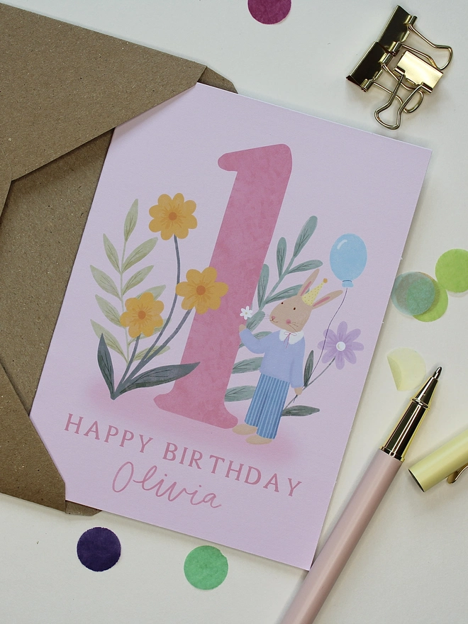 personalised floral 1st birthday card. pink 1st birthday card with illustrated rabbit and flowers.
