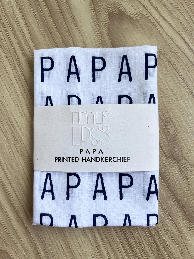 PAPA Handkerchief folded and packaged, on a wooden table
