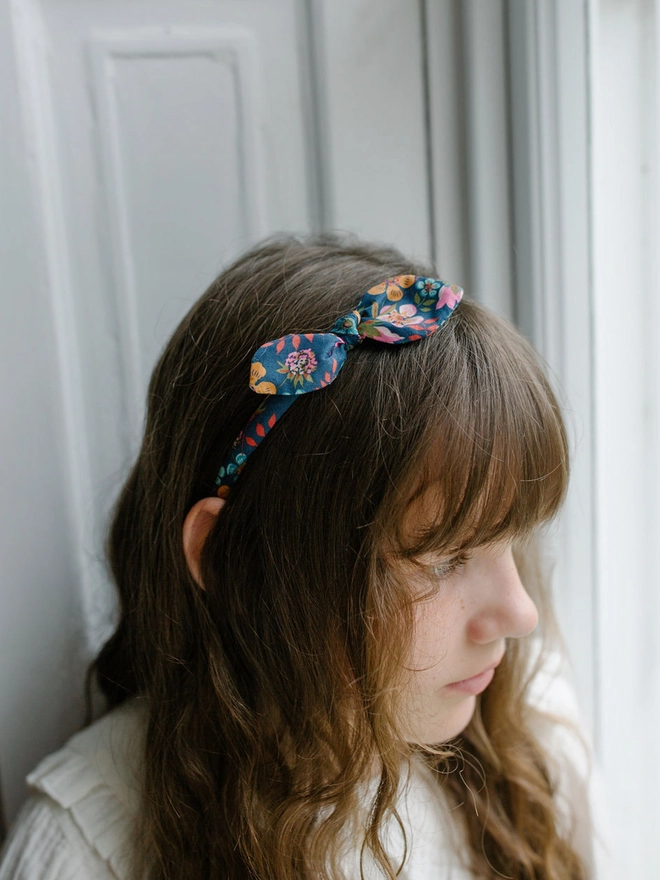 Grils with long brown hair and a liberty Alice band