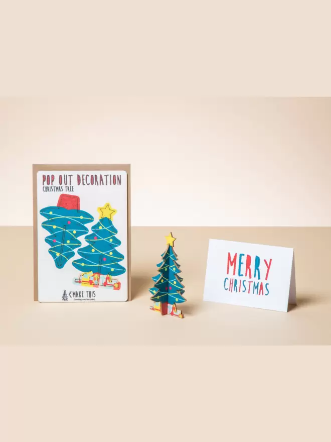 Pop out Christmas tree decoration and Merry Christmas card on a peach-coloured background