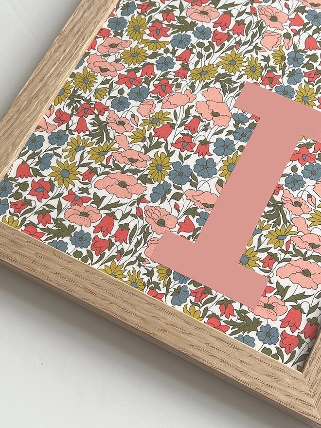 Personalised framed Liberty floral initial print with salmon pink lettering - close up