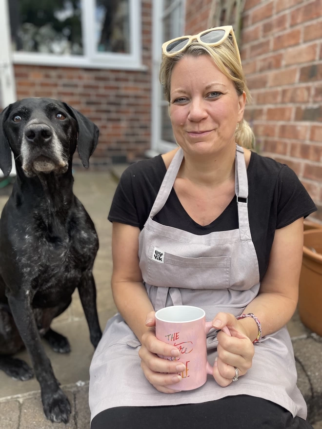 Sally having a tea break holding a cuppa with her doggy pal Otto