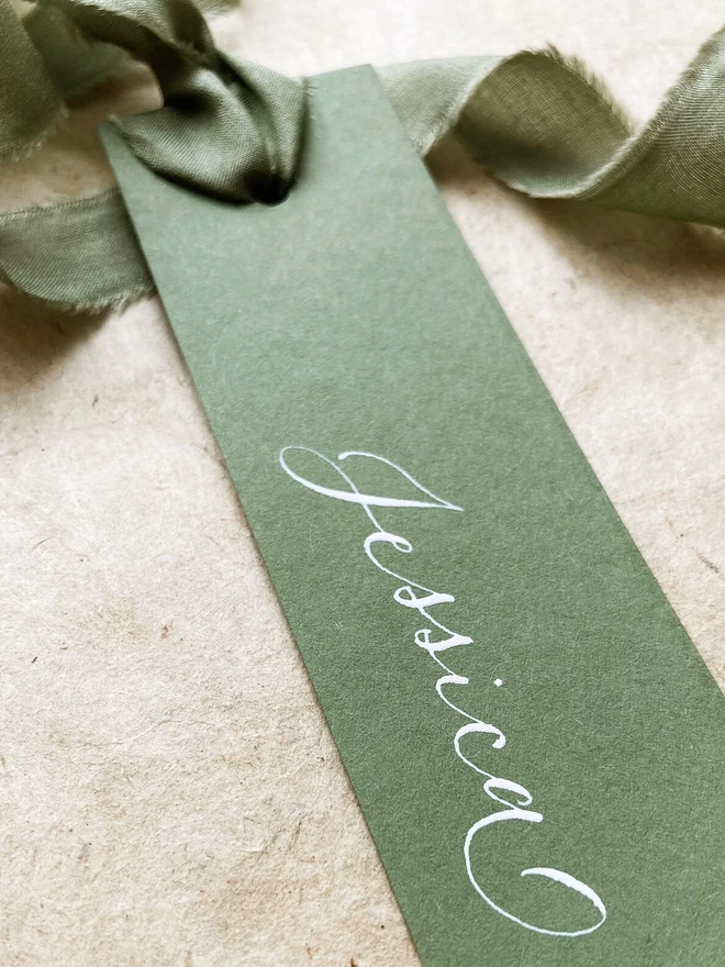 sage green calligraphy wedding place cards. green wedding place cards with silk ribbon and white calligraphy.