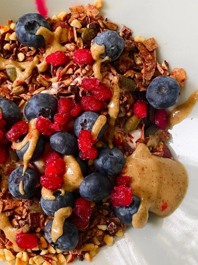 almond, brazil nut and cashew butter. a bowl of granola topped with fruit and ABC nut butter.
