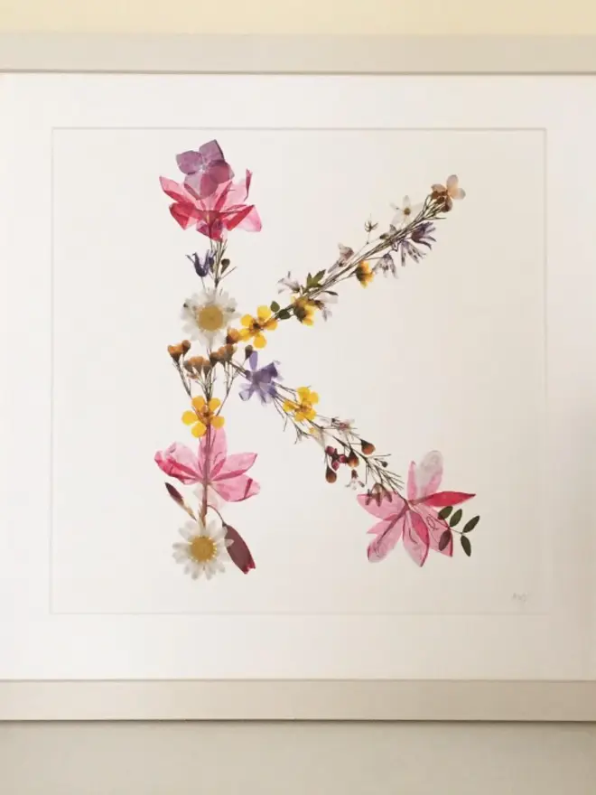 Pressed Wildflower Letter Print, a wildflower alphabet letter print sitting framed. 