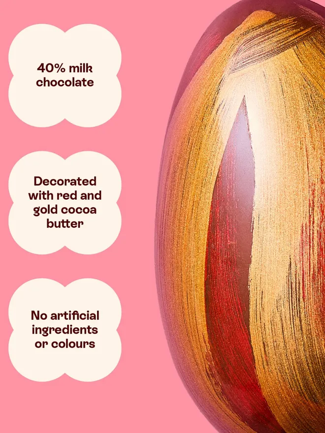 A milk chocolate Easter egg decorated with red and gold cocoa butter