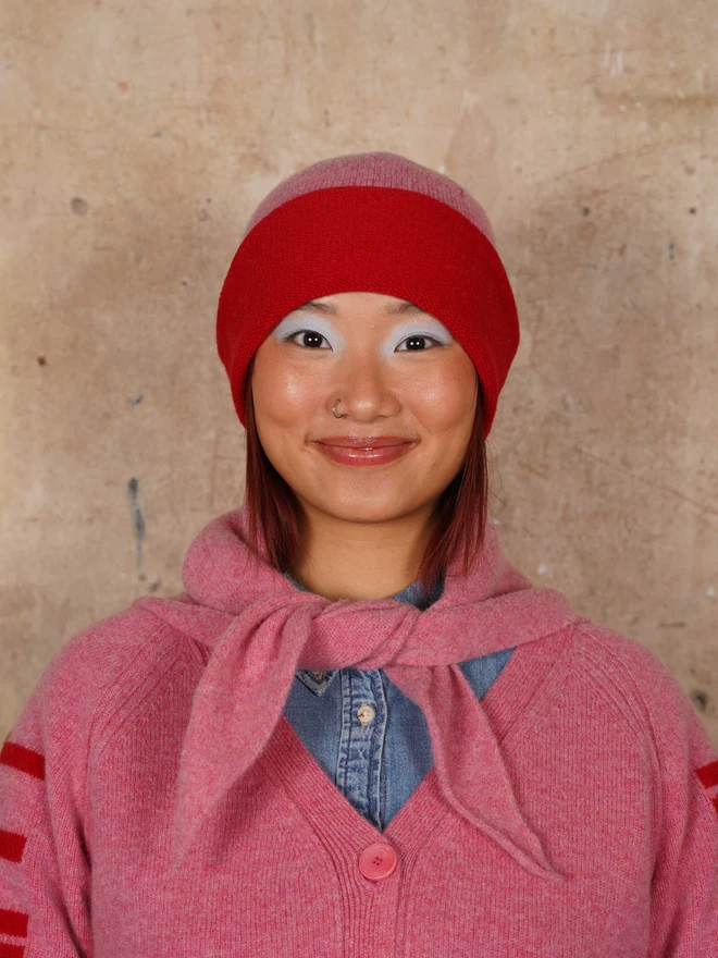 Model wearing the Colour Block Beanie in French Rose & Rouge along with the neck tie and matching jumper